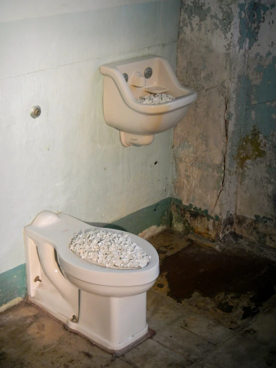 a toilet and sink in a bathroom with old wall