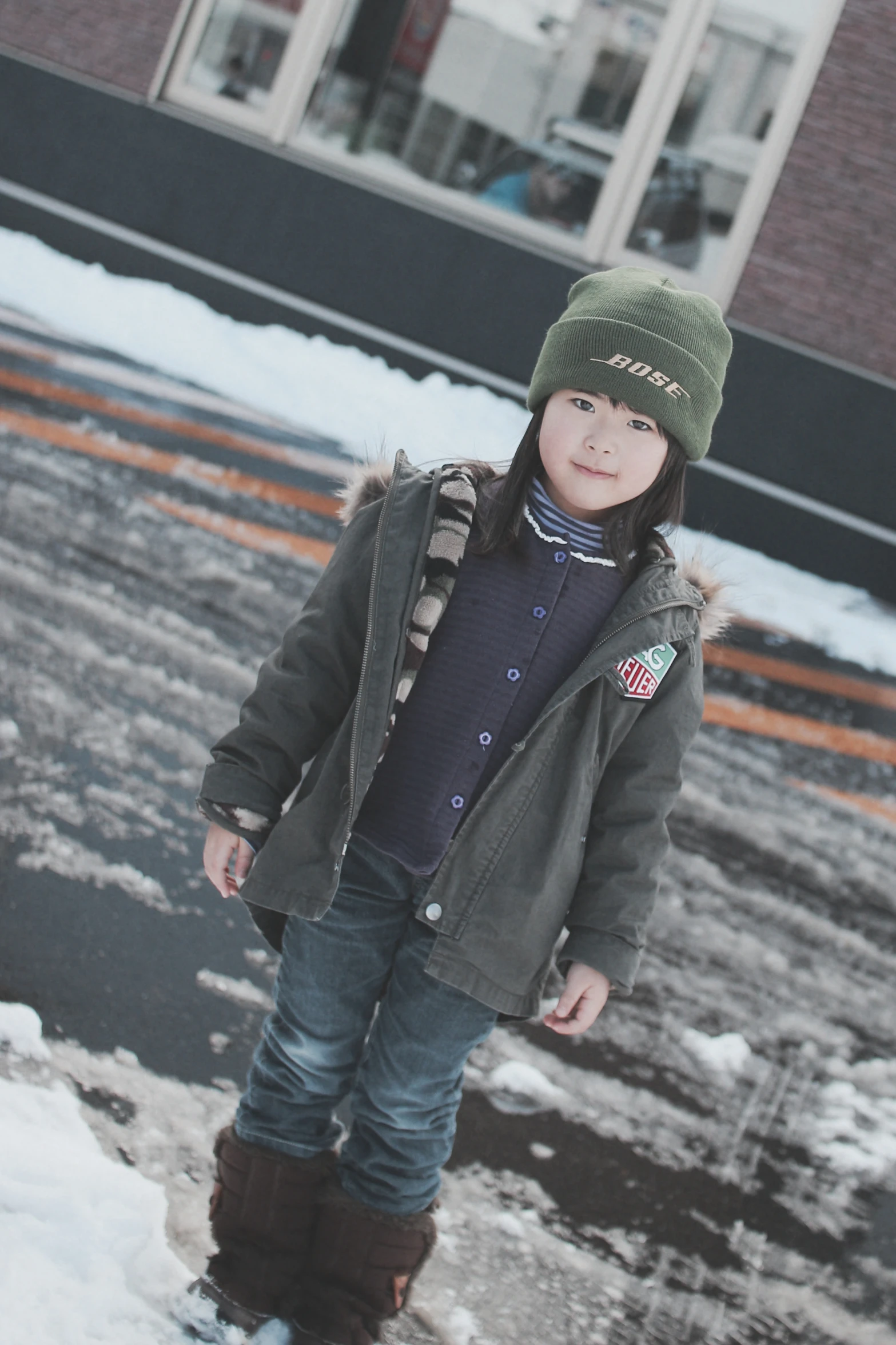 a little girl wearing winter clothes posing in the snow