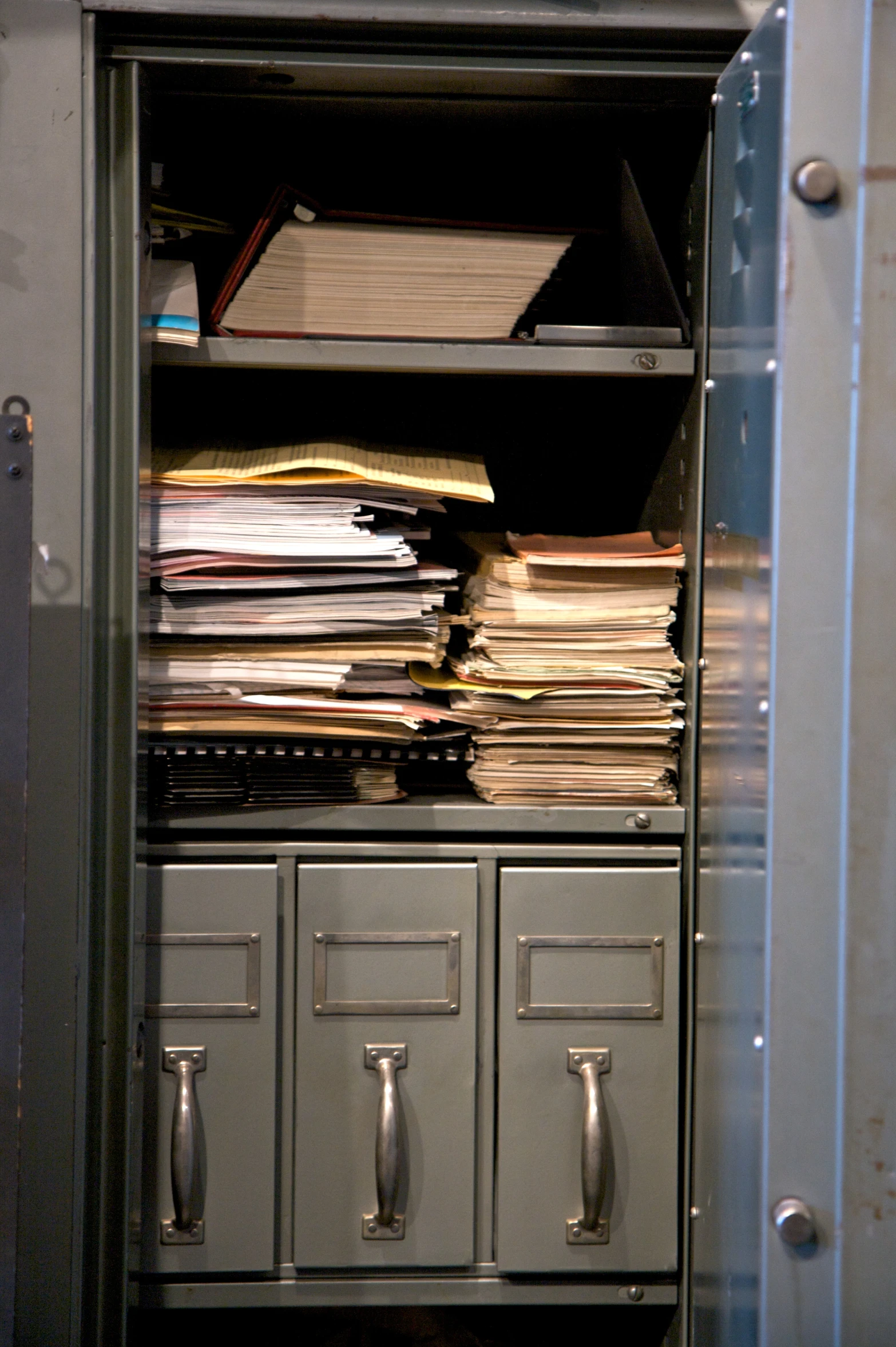 several drawers are full of files next to a filing cabinet