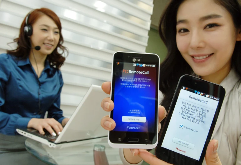 two women with headsets on looking at cellphones