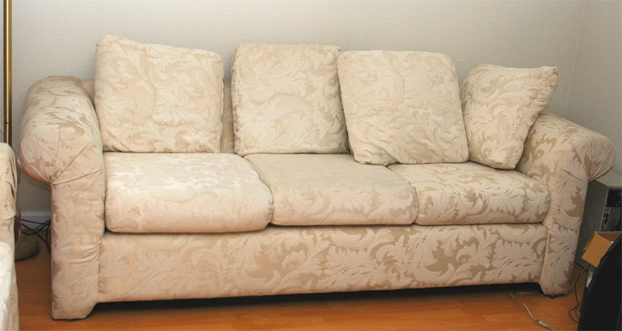 this couch is up against the wall with beige floral patterns