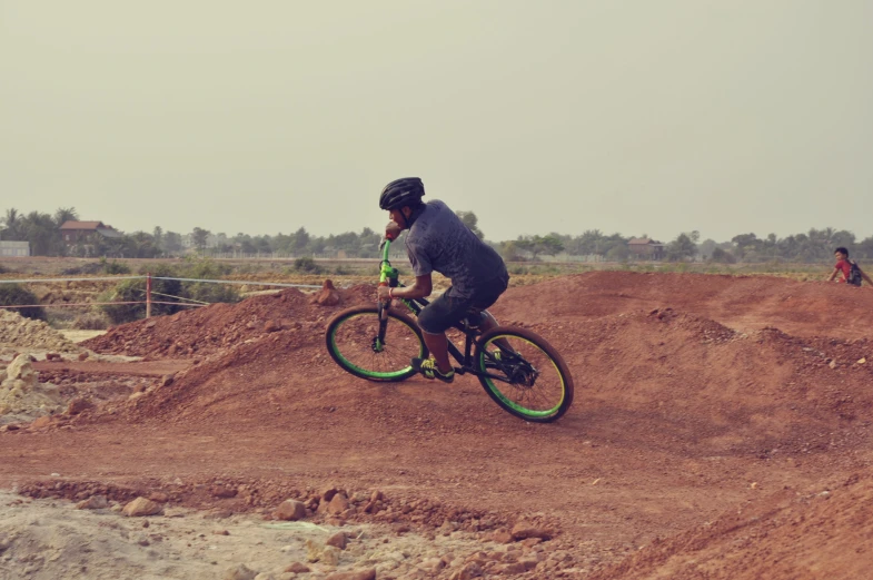 a man riding on the back of a bike on a dirt field
