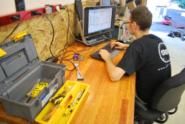 a guy working on a computer with tools and gadgets