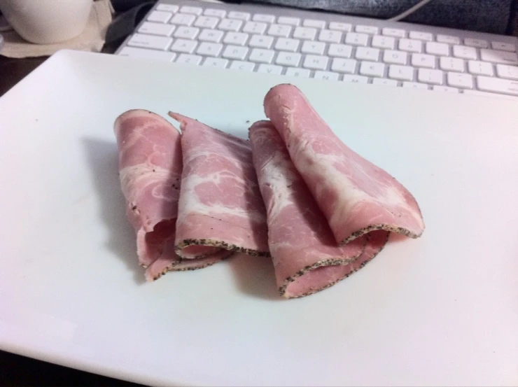 bacon rolls on a white surface near a computer