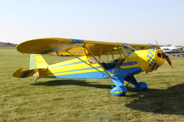 an older plane on a grassy field next to other vehicles