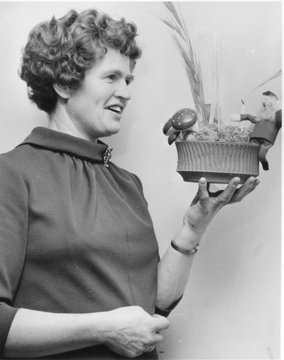 black and white pograph of woman holding small potted plant