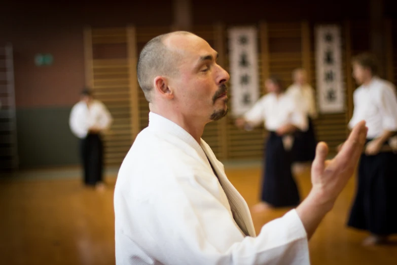 an older man holding a knife up to someone in a dance class