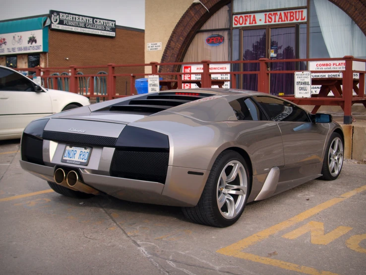 a shiny car sitting outside of a showroom