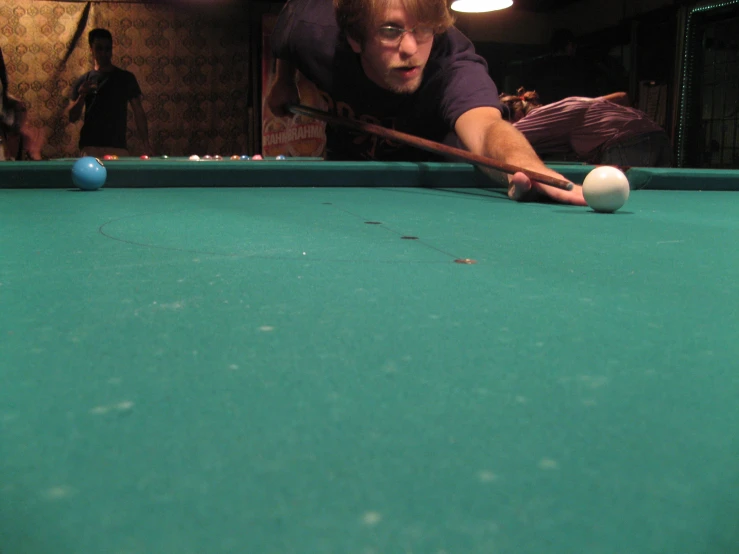 a man about to strike the ball on a pool table