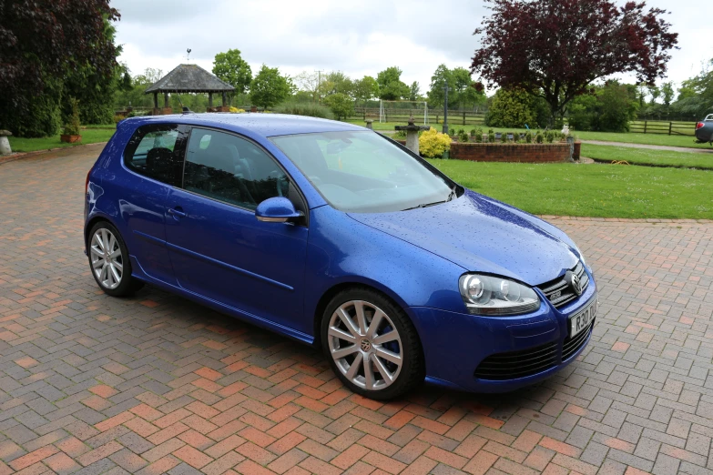 a blue volkswagen golf car parked in a driveway