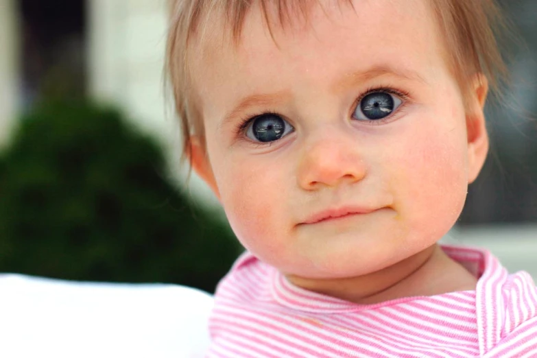 a young child looking into the camera with blue eyes