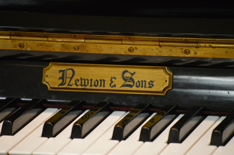 the keys of a black and gold piano