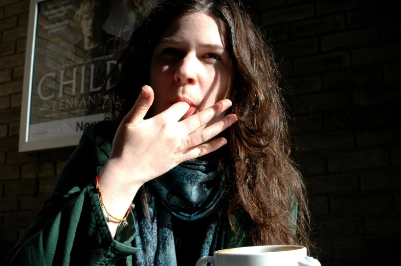 a young woman looks in her coffee cup