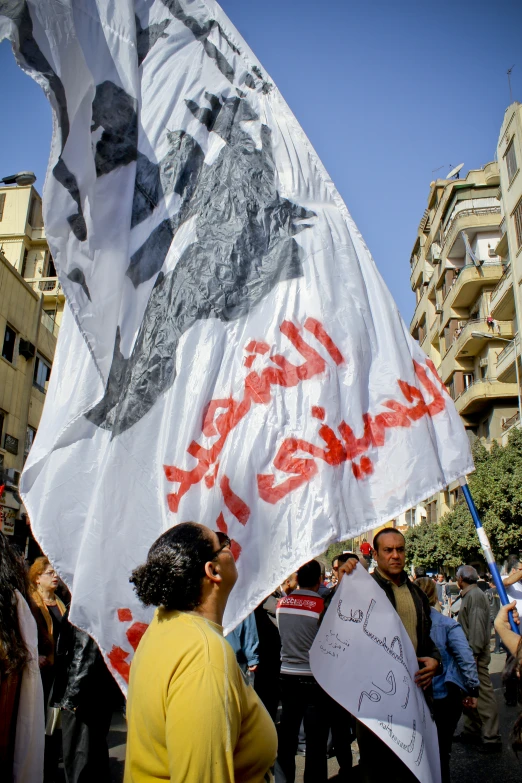 a woman is holding up a banner outside