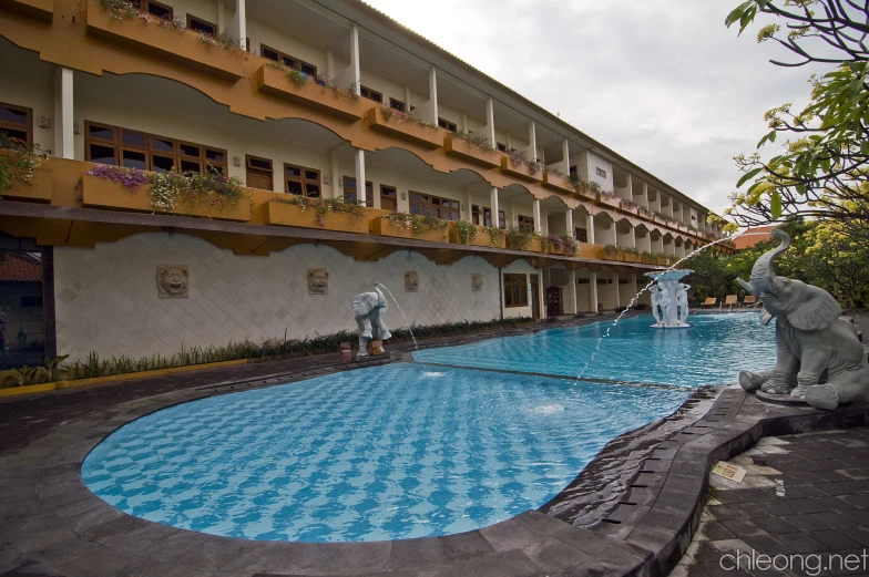 some statues sitting by a big blue pool