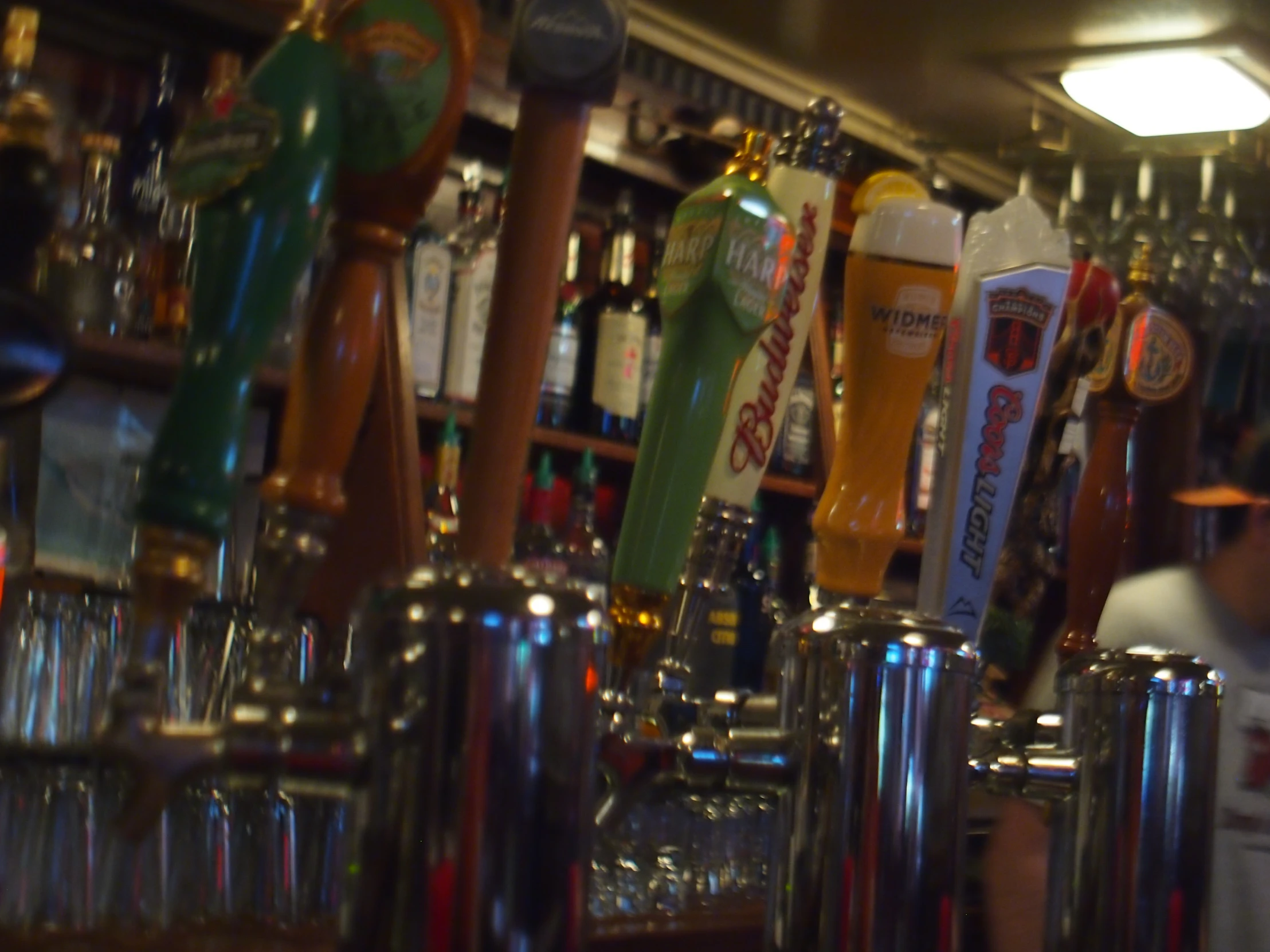 a view of many glasses at the bar with beers in it