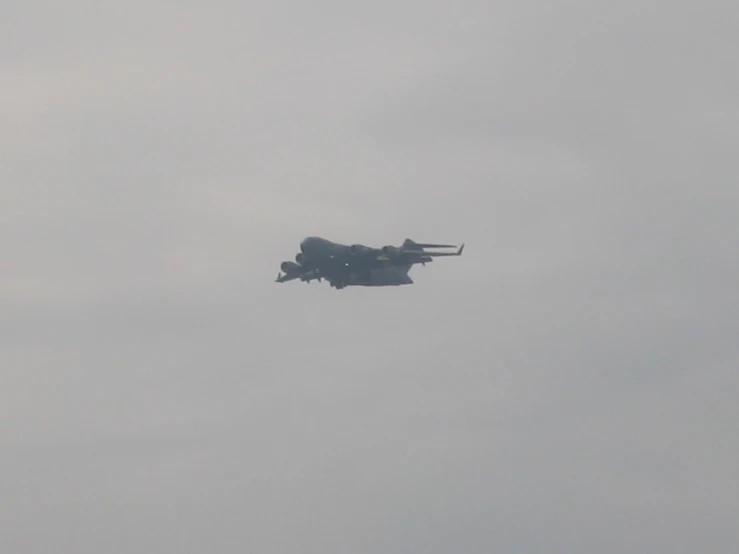 a large military aircraft with military vehicles flying