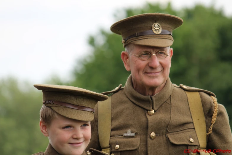 a soldier posing with his grandfather during the day