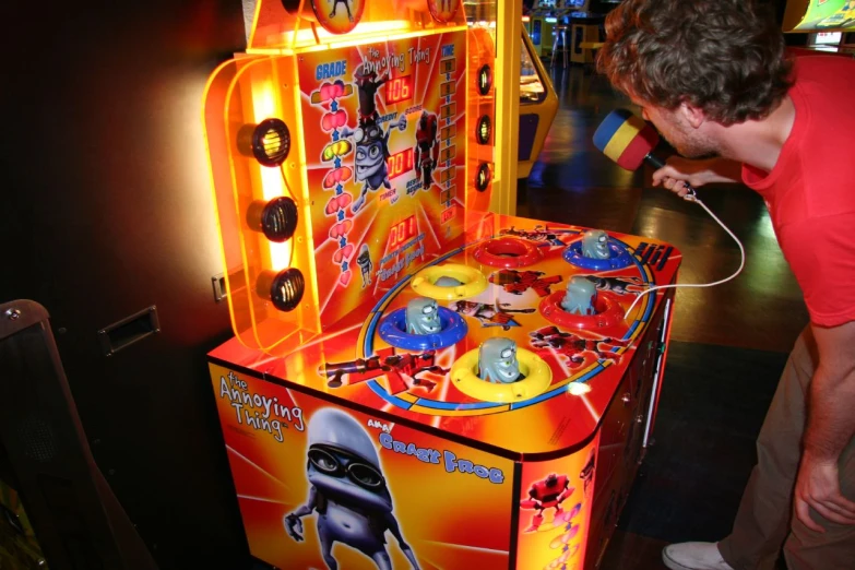 a man playing video games with an orange cabinet