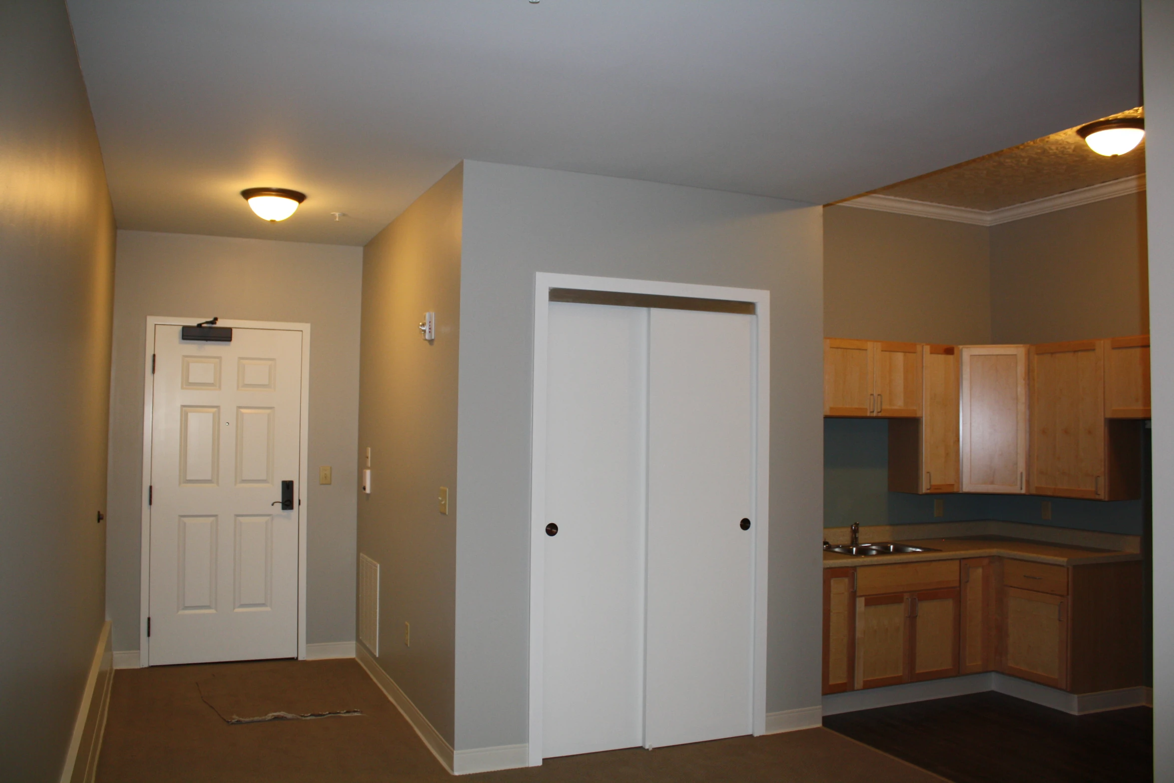 an empty kitchen with two open doors in it