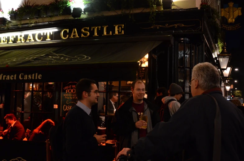 two men are talking outside of the pub