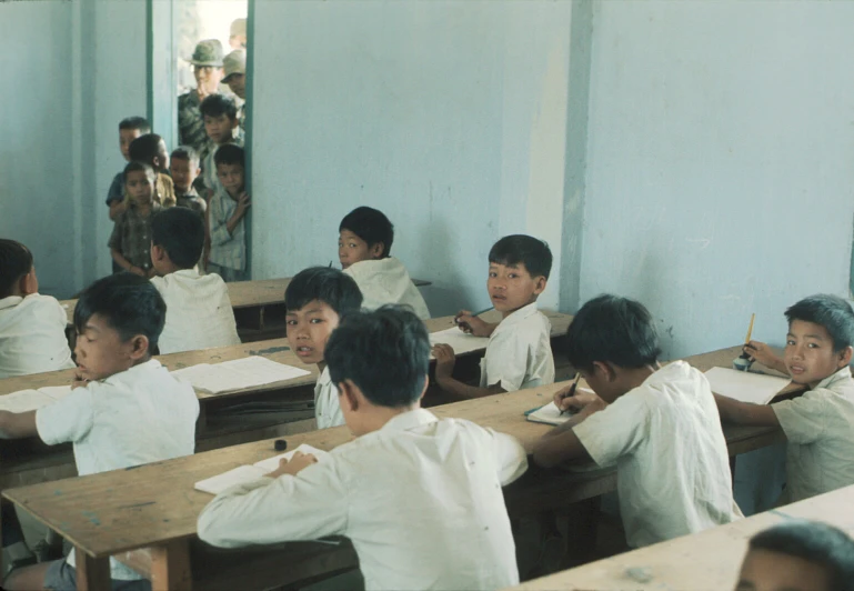 a group of s sitting at desks in a classroom