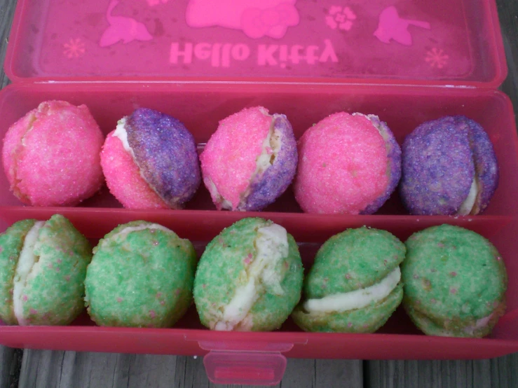 many different color decorated doughnuts in a tray