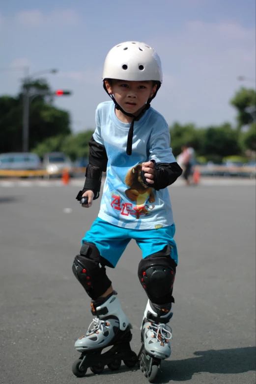 little boy on a skateboard is wearing a helmet