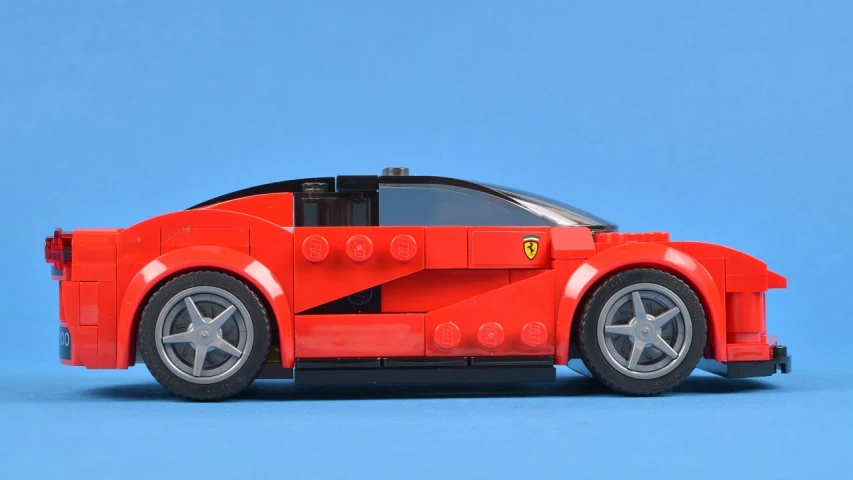 a red car made out of lego bricks sitting on the ground