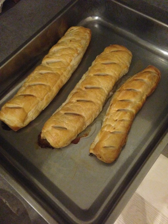 two long loafs of bread sitting in the middle of a baking pan