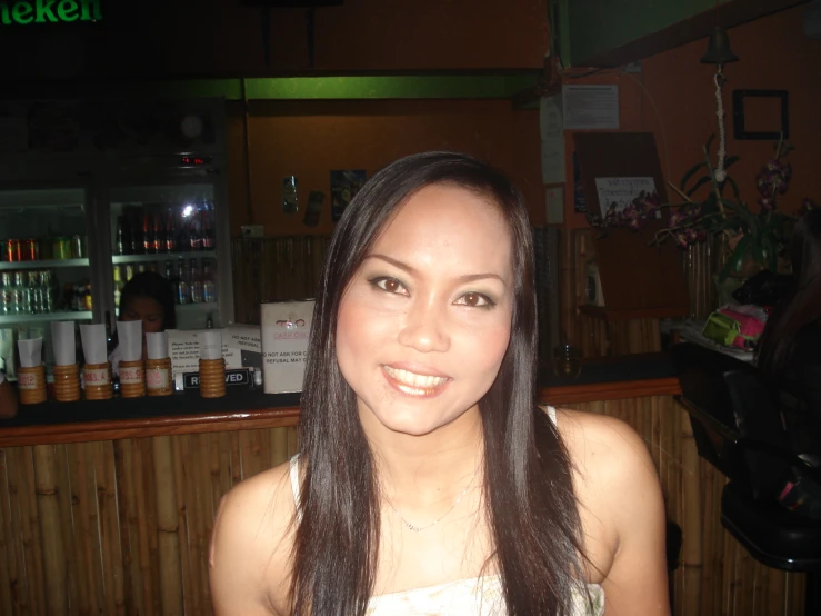 a woman posing at a bar while smiling for the camera