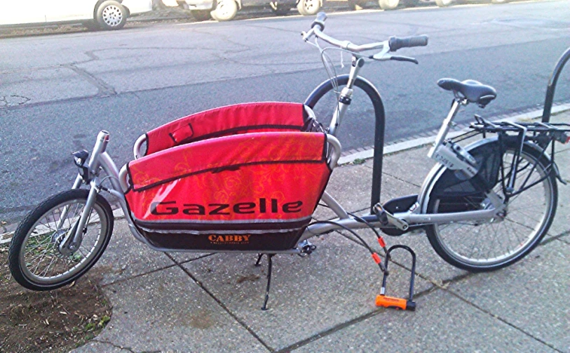 a bike parked next to a bike carrier on a sidewalk