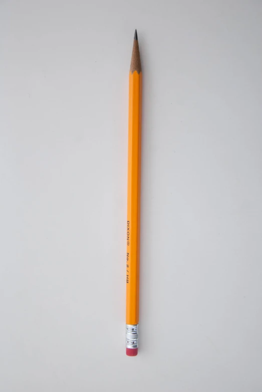 a pencil is standing upright against a wall