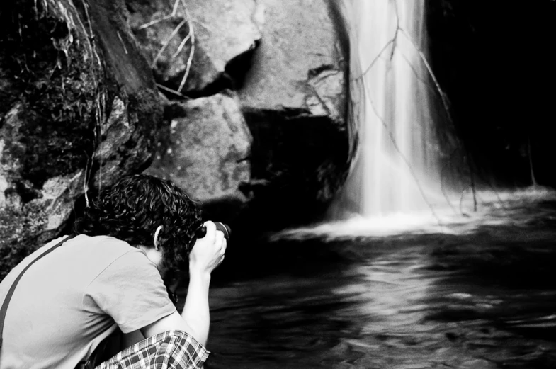 there is a woman looking at the waterfall