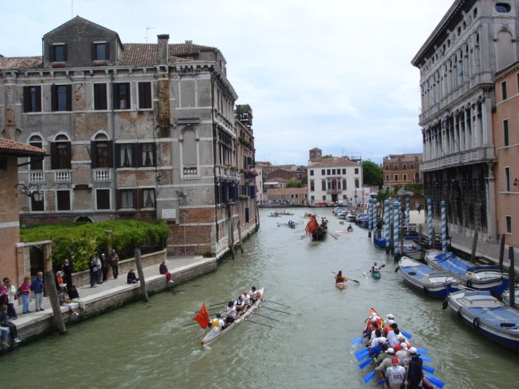 people are riding canoes in a busy river