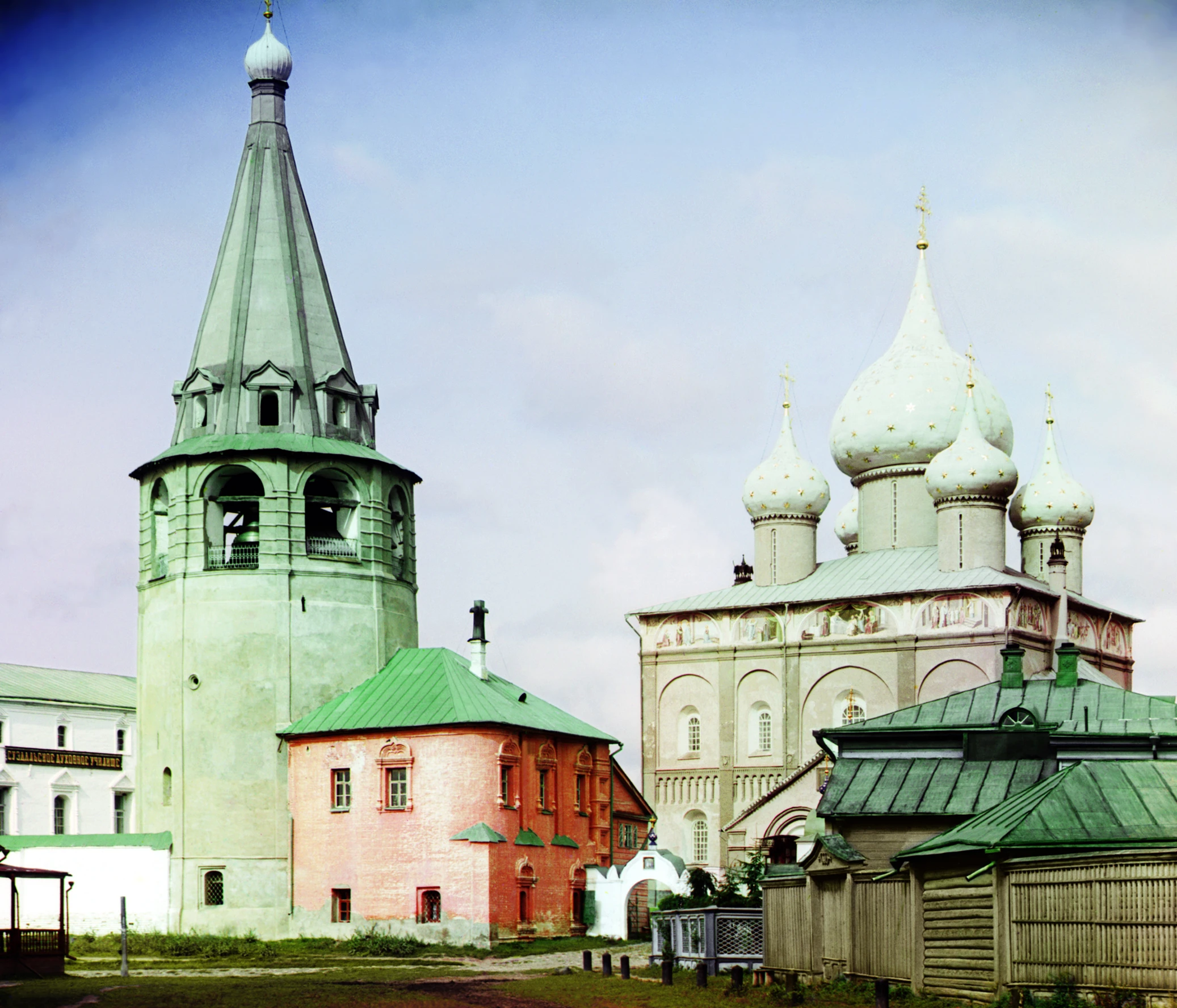 large buildings are all green and white and one has a tall clock tower