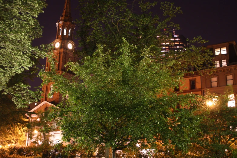 view of a large building at night with a steeple lit up