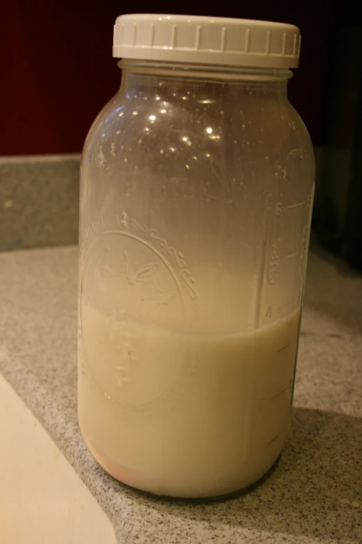 a clear glass jar filled with liquid next to a white counter