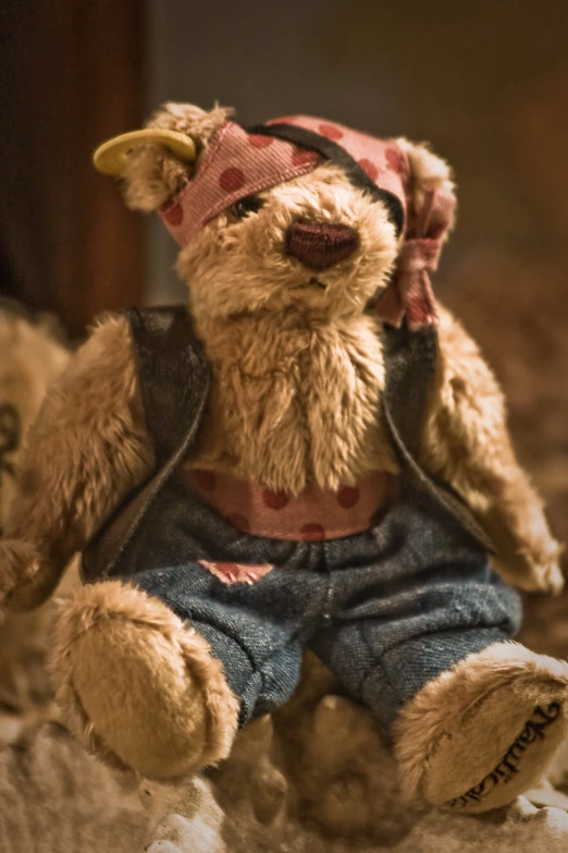 teddy bear with bandanna and hat on sitting next to other stuffed animals