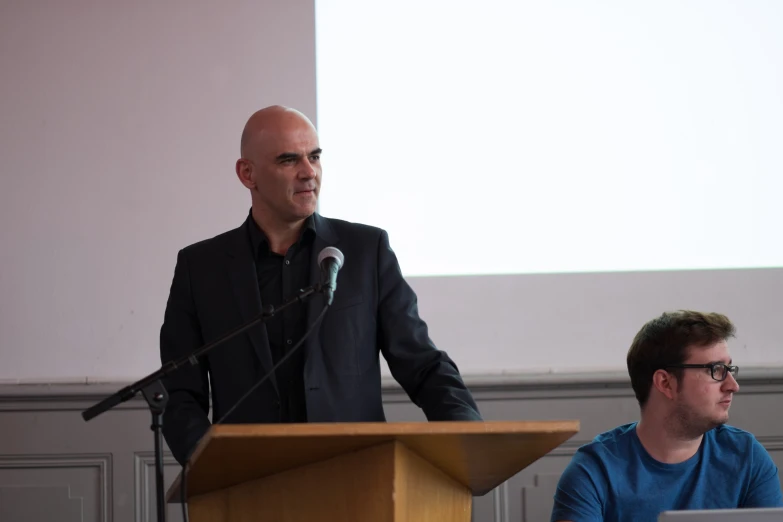 a man giving a speech at a conference