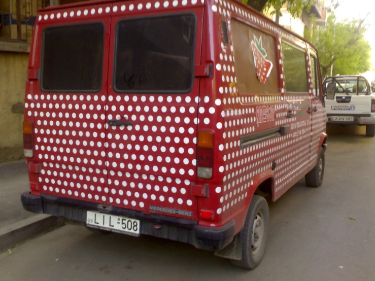 red van with white polka dots parked on the side of the street