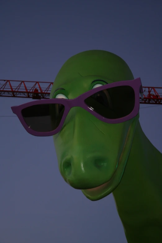 green, purple and white animal with purple sunglasses and red crane