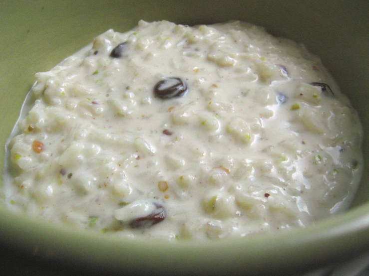 a spoon is holding a bowl of rice with raisins