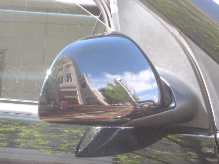 the reflection of buildings in the mirror of a car