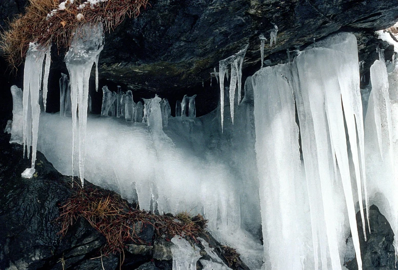 the frozen icicles are hanging from the rocks