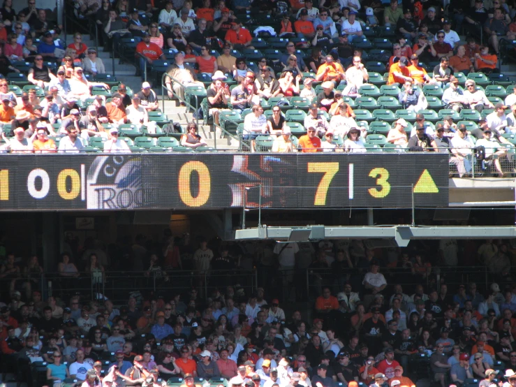 a crowd is looking up and down at a score board