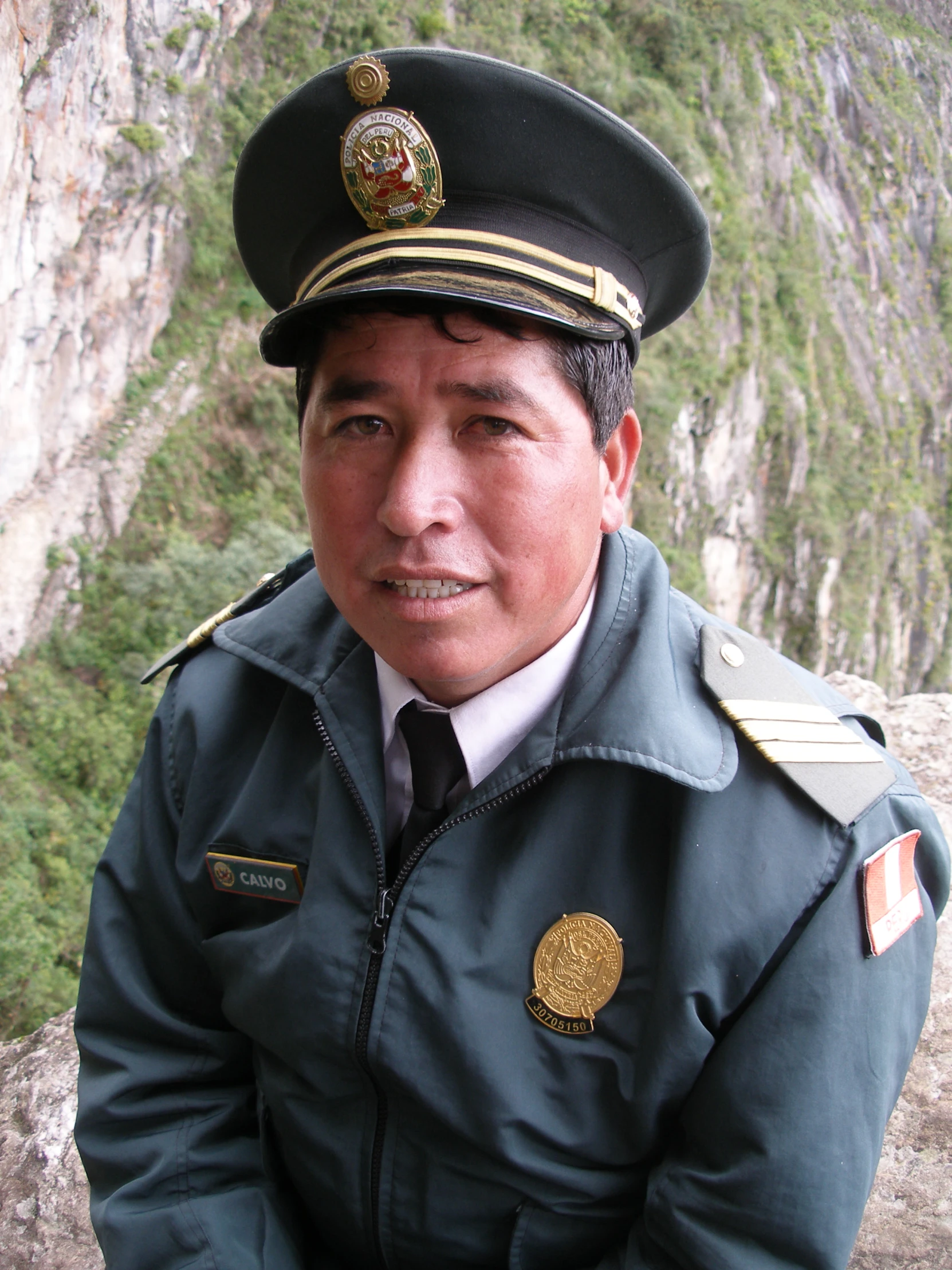 an asian man in uniform with rocky area in background