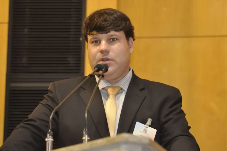 man sitting at a podium making a speech