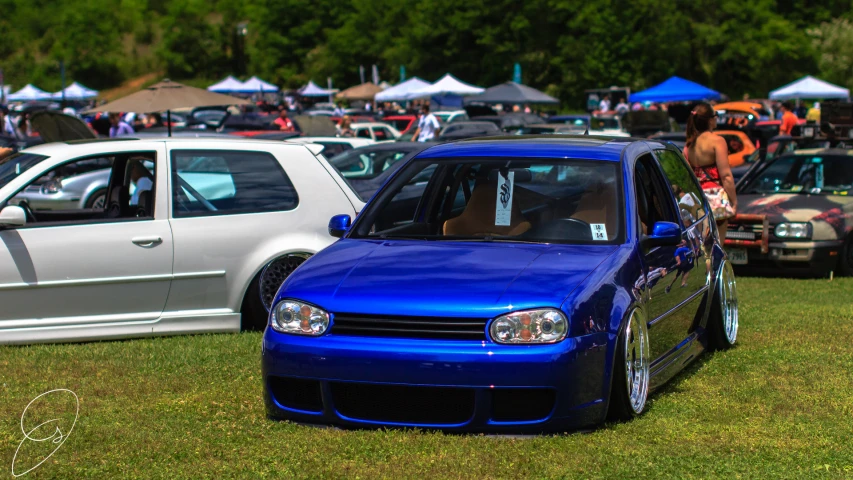 the blue car is parked beside the silver van