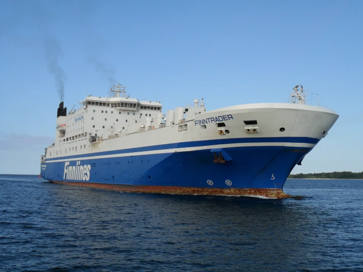 an large white and blue ship sailing on the ocean